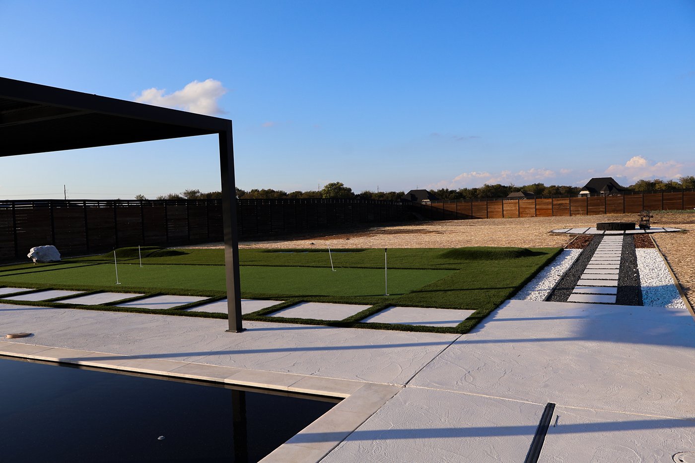 Putting green, paver walkway and pool deck